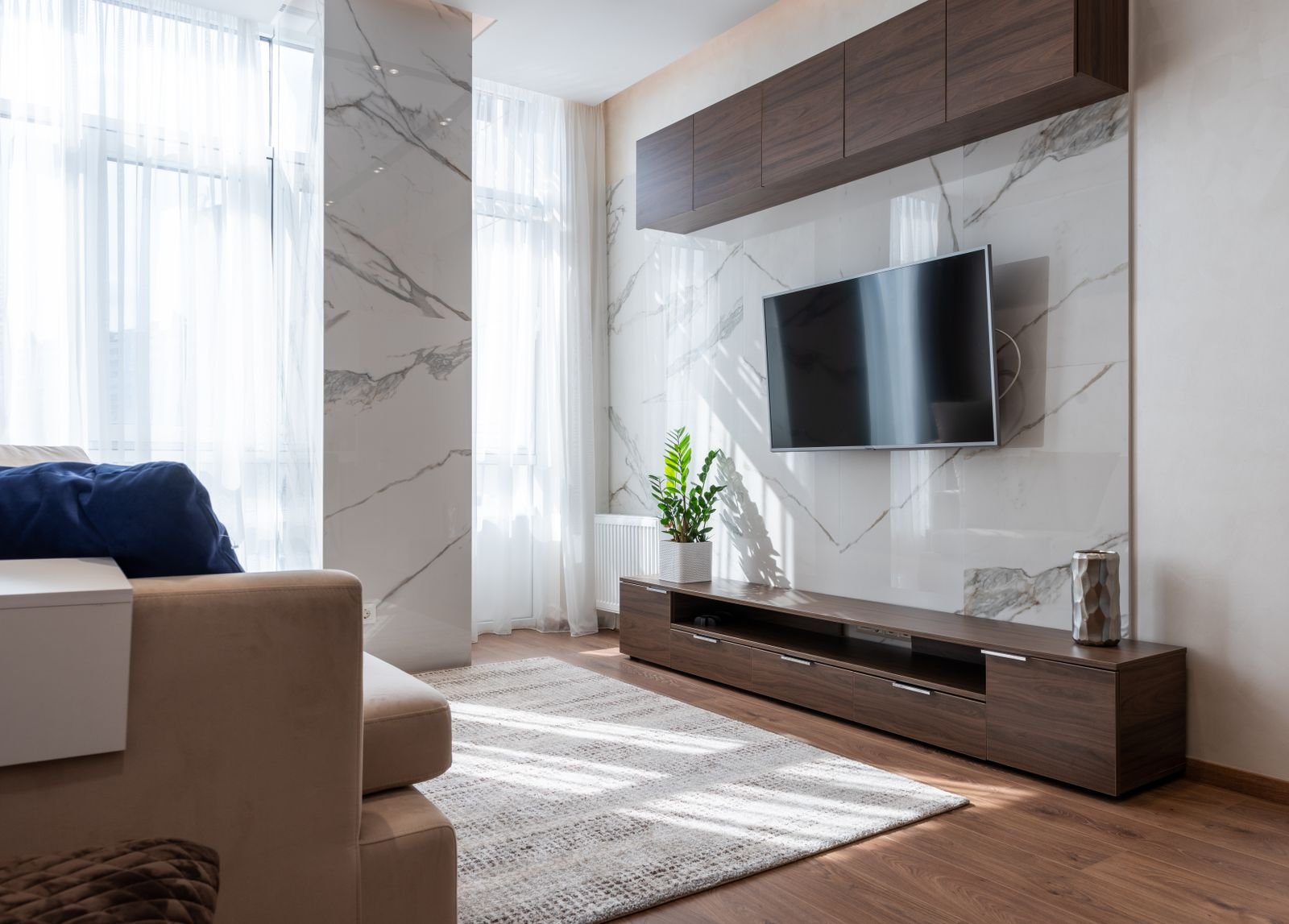 Modern living room with wall-mounted TV and fitted storage in a Manchester home